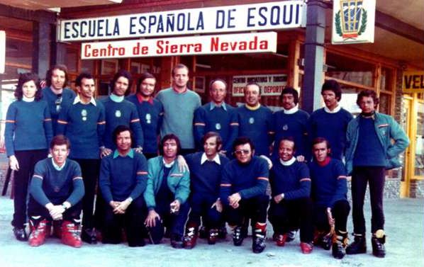 Foto histórica de los años 70: el rey de España, Juan Carlos I, con el equipo de profesores de la Escuela Española de Esquí ante el rótulo «Escuela Española de Esquí. Centro de Sierra Nevada»